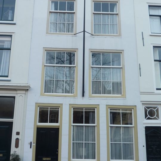 Pand met gepleisterde lijstgevel. Stoephek en hardstenen palen