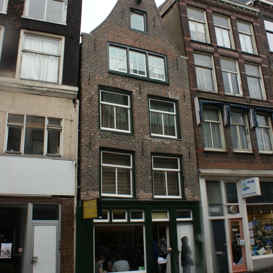 Pand met gevel onder vaag klokvormige top met rollagen