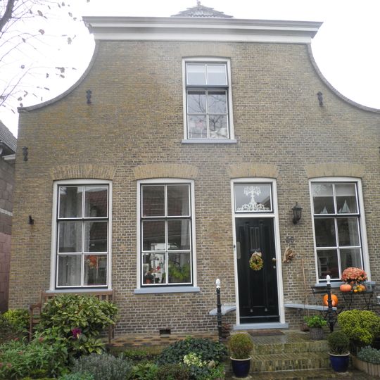 Dorpshuis onder zadeldak tussen ingezwenkte afgeknotte halsgevel en puntgevel achter