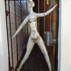 An outline of a person, painted in silver, attached to the gate