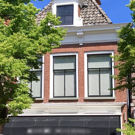 Pand onder zadeldak met voorschild met versierde dakkapel en schoorsteen met bord