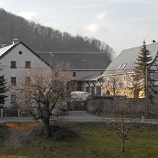 Wohnstallhaus und zwei Seitengebäude eines Dreiseithofes, mit hölzerner Inschrifttafel Dorfstraße 3