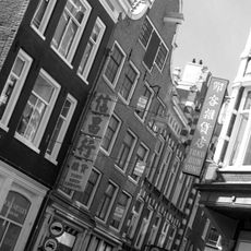 Twee huizen achter een gezamenlijke gevel met in- en uitgezwenkte top