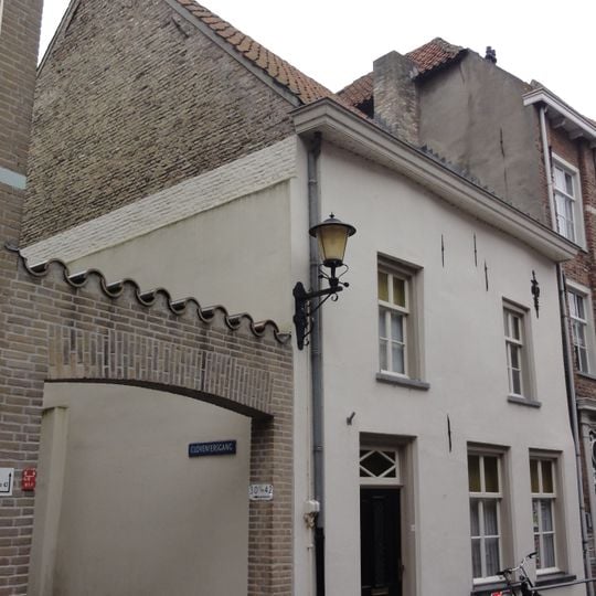 Huis met eenvoudige witte lijstgevel en sierankers