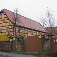 Wohnstallhaus und Scheune eines Bauernhofes mit Einfriedung, Hofmauer und Toreinfahrt Basteistraße 80