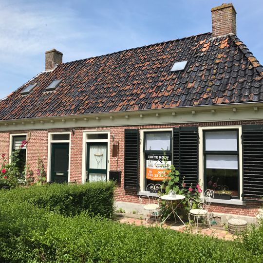 Pand met goot op klossen onder schilddak met hoekschoorstenen