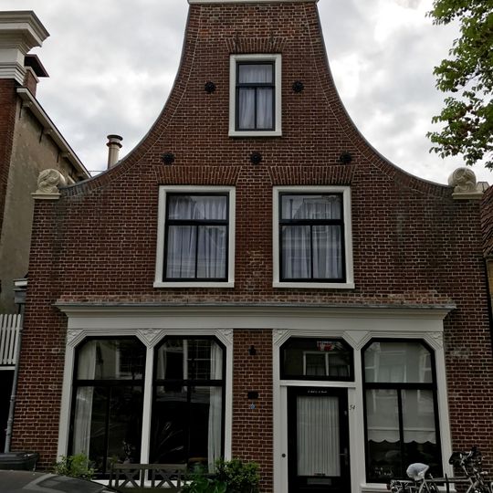 Pand onder zadeldak klokgevel met aanzetkrullen