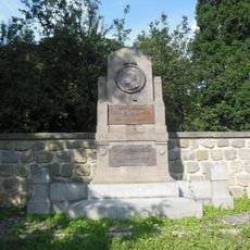 Pomník Emanuela Maxe u zdi zámeckého parku v Sloupu
