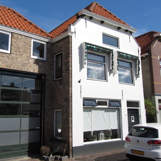 Huis met gepleisterde lijstgevel en in de verdiepingen oude kozijnen