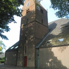 Toren van de Hervormde Kerk : drie geledingen met zadeldak. Segmentboogvormige ingang in hoge spitsboognis