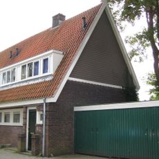 Blok met 4 keukenwoningen, zo genoemd vanwege destijds nieuwe plaatsing van keuken aan de voorzijde, aan de zijkant een houten topgevel, bouwstijl Amsterdamse School.