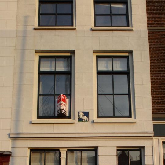 Pand met gepleisterde puntgevel - oorspronkelijk trapgevel- waarin een gevelsteen met steigerend paard