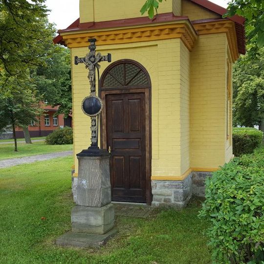 Kříž před kaplí na návsi v Tlustici