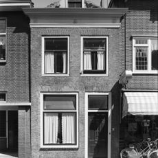 Lijstgeveltje van gele ijsselsteen met rode strekken boven de vensters