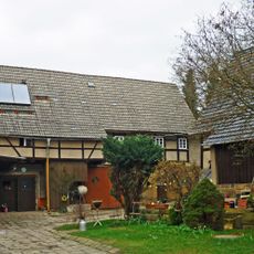 Scheune und Seitengebäude (mit Oberlaube) eines Vierseithofes sowie Toreinfahrt und Hofpflasterung Borngasse 13