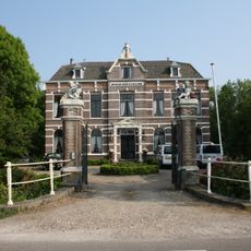 Huize van Strijen: toegangspartij bestaande uit twee hekpijlers en een toegangshek, bevindt zich aan de westzijde voor het weeshuis