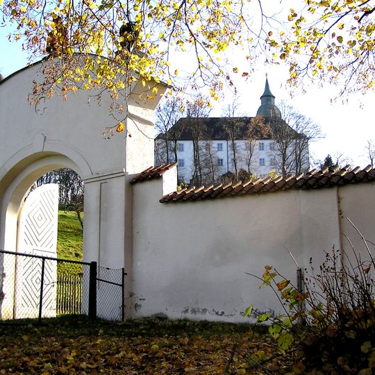 Klostergarten mit langer Einfriedungsmauer und Eck-Zinnentürmen, Schalentürmen und Toreinfahrt