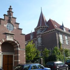 Dienstwoning bestaande uit één bouwlaag onder samengestelde kap met rode hollandse pan