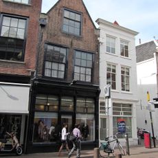 Pand met tot puntgevel gewijzigde trapgevel waarin schuiframen stijl