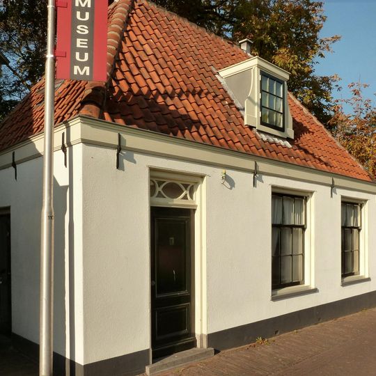 Laag huis met rechte kroonlijst nabij de Nederlands Hervormde Kerk