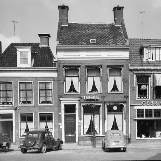 Woonhuis met verdieping onder hoog dwarsdak tussen topgevels waarboven schoorstenen