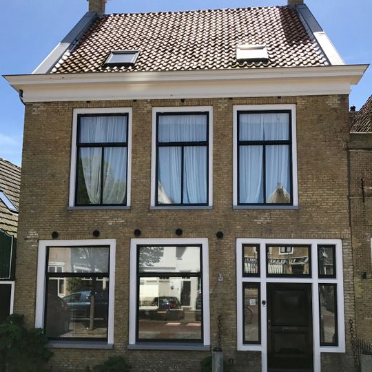 Pand met verdieping onder dwars zadeldak tussen topgevels met oudere hoekschoorsteen