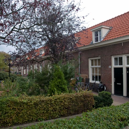 Dubbele rij van vierentwintig rug-aan-rug gebouwde woningen, op rechthoekige plattegrond bestaande uit een bouwlaag onder een met pannen gedekt mansardedak
