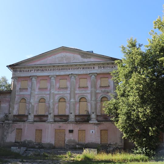 Здание городской больницы с оградой и решеткой