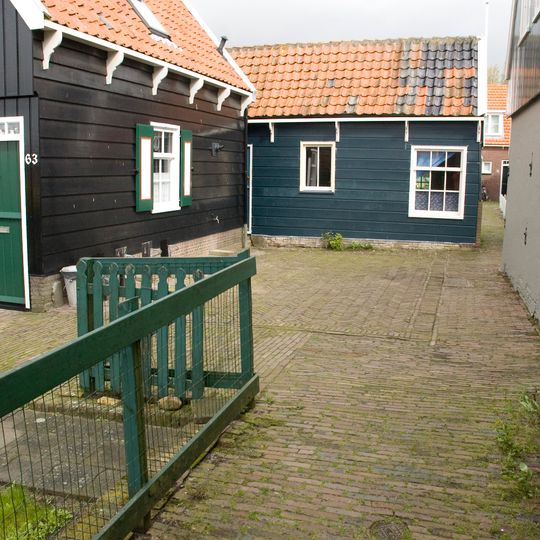 Houten huis met topgevel en daklijst op consoles