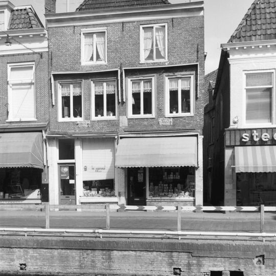 Twee panden onder diep zadeldak en met gevel waarvan de top vervangen is door dakschild en rechte kroonlijst