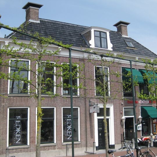 Zeven traveeën breed herenhuis met sobere gevel met middenrisaliet onder tentdak met hoekschoorstenen