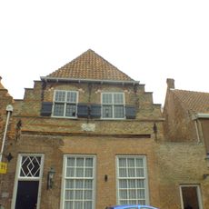 Huis met kleine trapgevel uit omstreeks 1600, met friezen waarin vullingen van metselmozaïek evenals in de boogvelden van de vensters