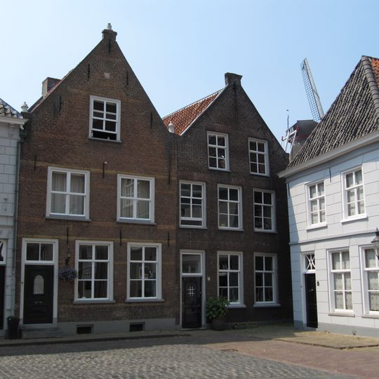 Huis met tuitgevel met vlechtingen en versierde top, achtergevel met schilddak aan de postweg