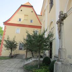 Kříž u vchodu do kostela sv. Antonína Paduánského v Dačících