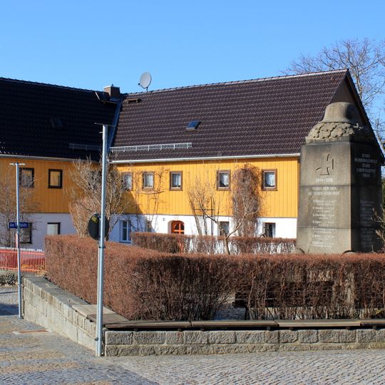 Wohnhaus über winkligem Grundriss, rückwärtige Scheune und Einfriedung Am Dorfplatz 14
