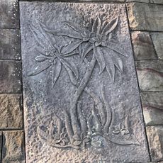 Relief in the stone retaining wall depicting flowers.