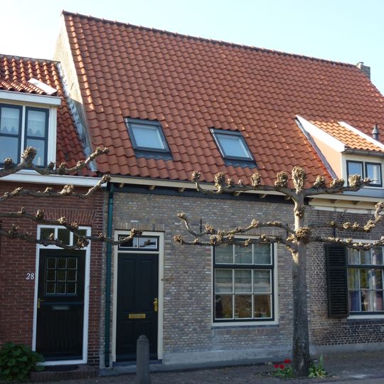 Huis onder zadeldak met langsgevel aan de straat. Schuiframen met negen ruiten