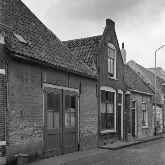 Eenvoudig huisje met geverfde langsgevel aan de straat