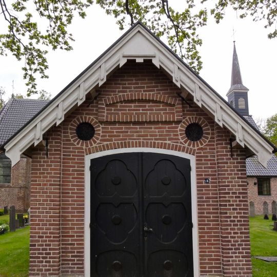 Baarhuis en toegangshek op negentiende-eeuwse kerkhof, rondom de van oorsprong veertiende-eeuwse kerk , die tegenwoordig wordt gebruikt door de Hervormde Gemeente