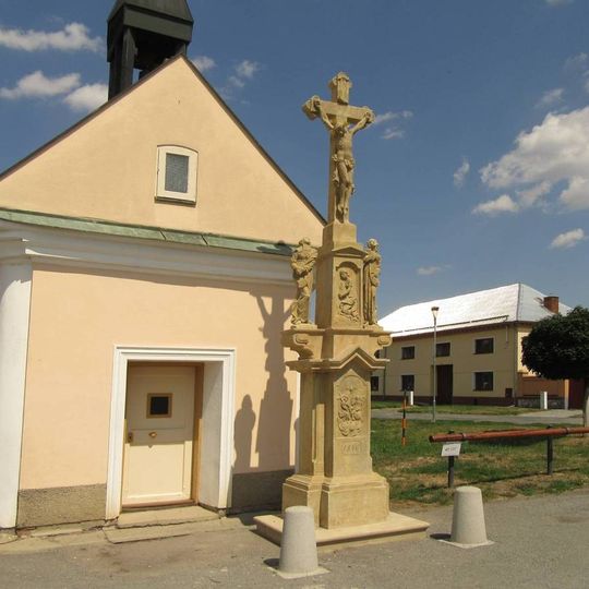 Kříž v Mezicích před kaplí na návsi