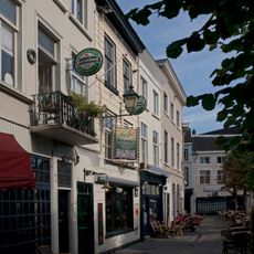 Pand met gebosseerd geelgepleisterde lijstgevel