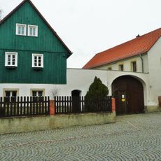 Wohnstallhaus, Seitengebäude und Torbogen eines Dreiseithofes Kirchplatz 18