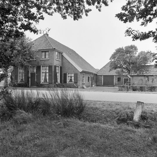 Bakhuis opgetrokken in baksteen onder een met grijze muldenpannen gedekt zadeldak