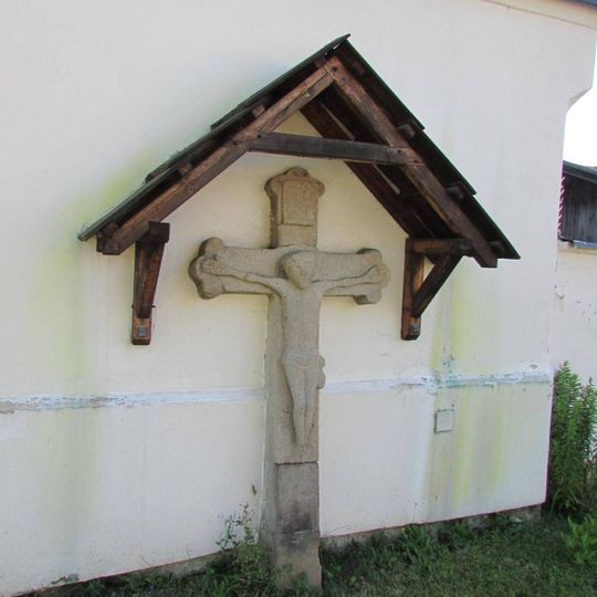Kříž z kamene vedle kaple v Hněvkovicích