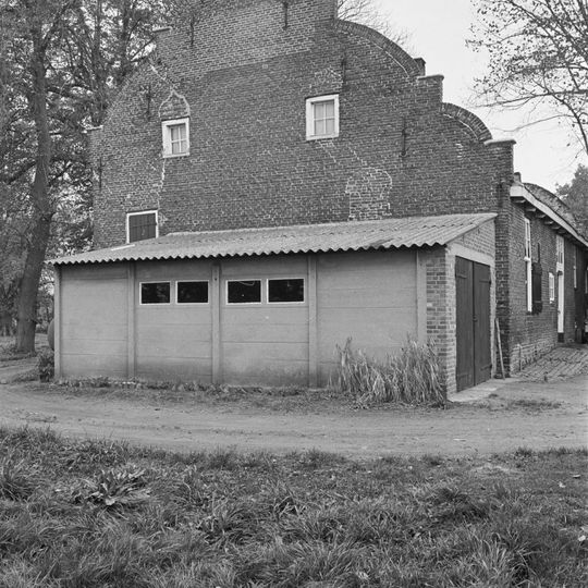 Boerderij waarvan het woongedeelte bestaat uit begane-grond onder hoog, met pannen gedekt zadeldak tussen gevels met in- en uitzwenkende contouren en tussentrappen