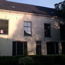 Gepleisterd pand onder zadeldak gedekt met pannen