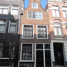 Huis met gevel onder klokvormige top met rollagen