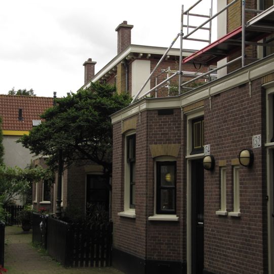 Blok van vier rug-aan-rug gebouwde woningen op vierkante plattegrond, bestaande uit begane grond en verdieping onder een plat dak