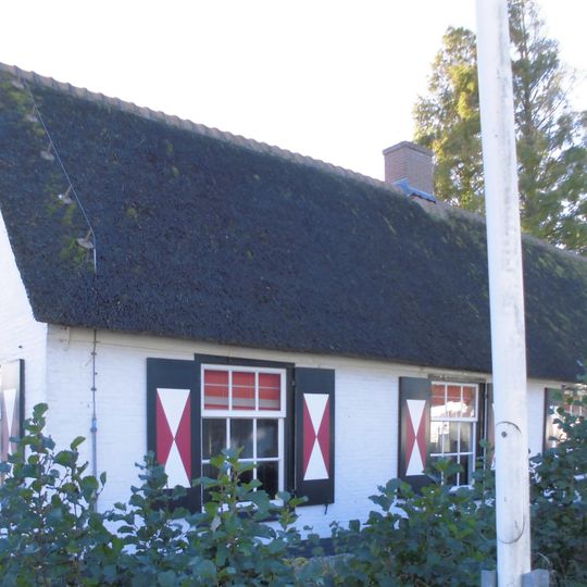 Lage gepleisterde woning, met riet gedekt