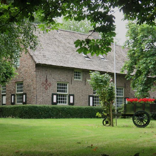 Boerderij ten dele opgetrokken van secundair verwerkte Middeleeuwse moppen. Woongedeelte onder pannen wolfdak, aan de achterzijde aansluitend tegen een puntgevel